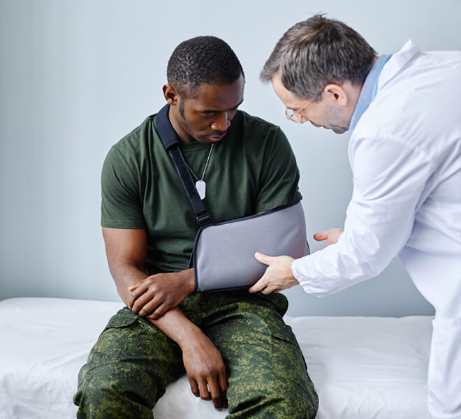 Doctor performing independent medical exam for soldier with arm injury