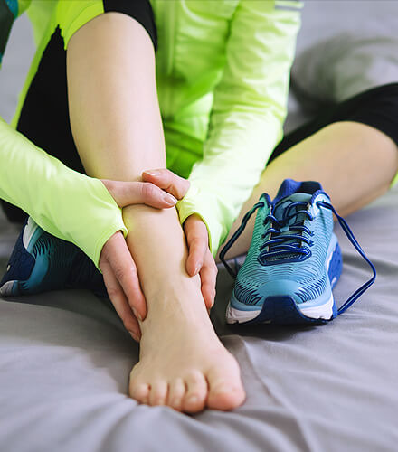 close-up of person holding ankle in running gear