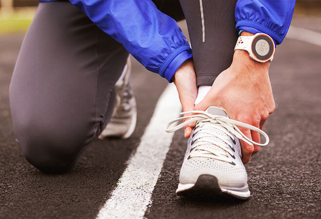 Up close shot of a young man holding his sprained ankle in pain