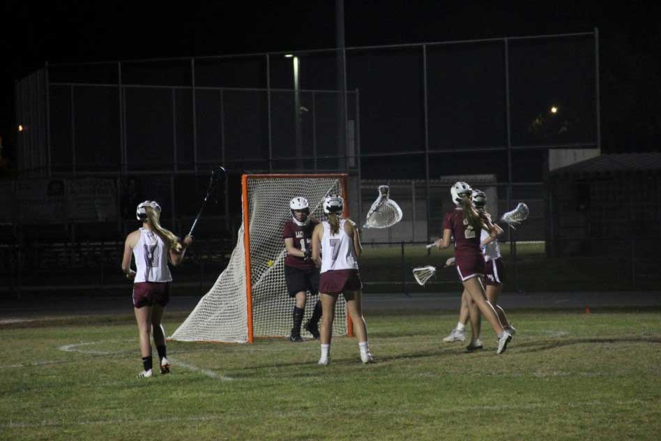 lacrosse team scoring point at goal