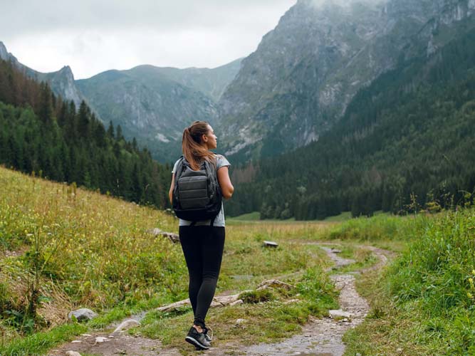 woman hiking solo with mountains in the background