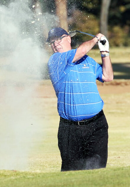 man following through on golf swing