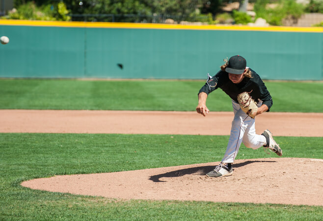 Baseball player throwing pitch after treatment for valgus extension overload