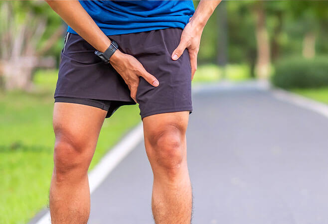 Young male suffering from groin muscle strain during his run