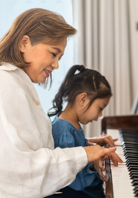 woman and little girl playing piano