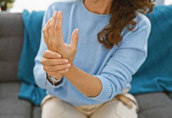 Mature woman experiencing nerve damage wrist pain at home