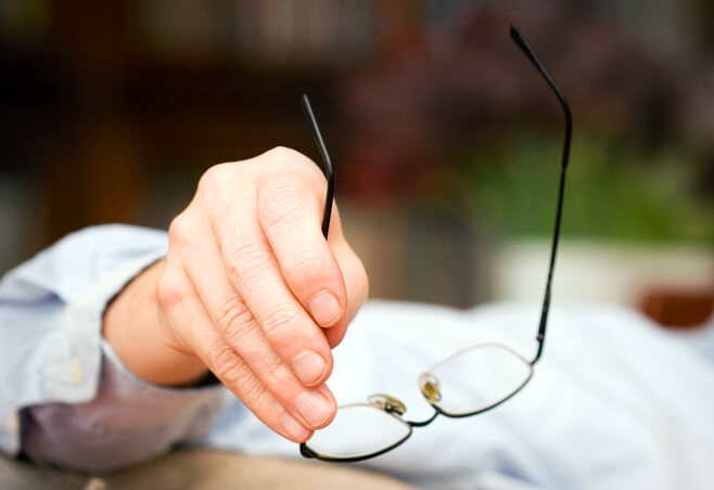 Man holding eyeglasses