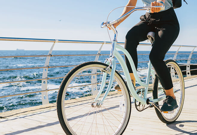 Woman cycling along the shore