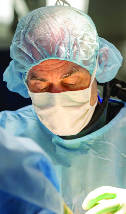 close-up of masked surgeon performing surgery