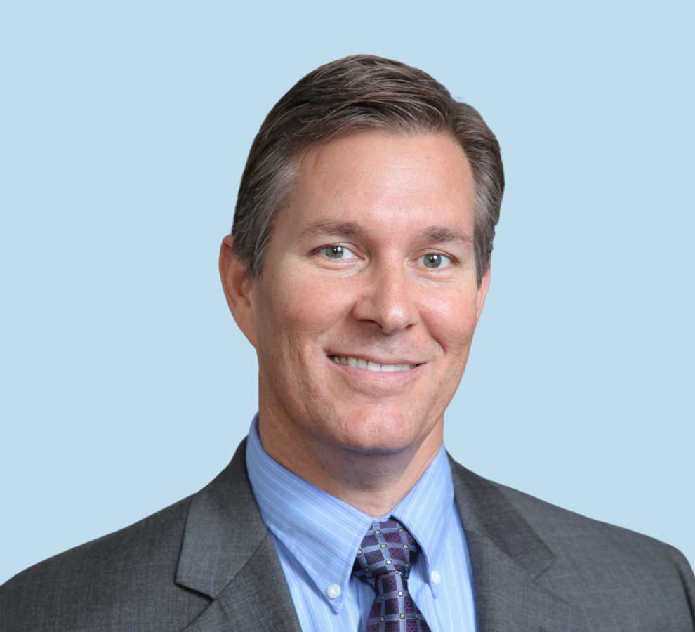 Adam C. Morse, DO professional headshot wearing gray suit with patterned tie