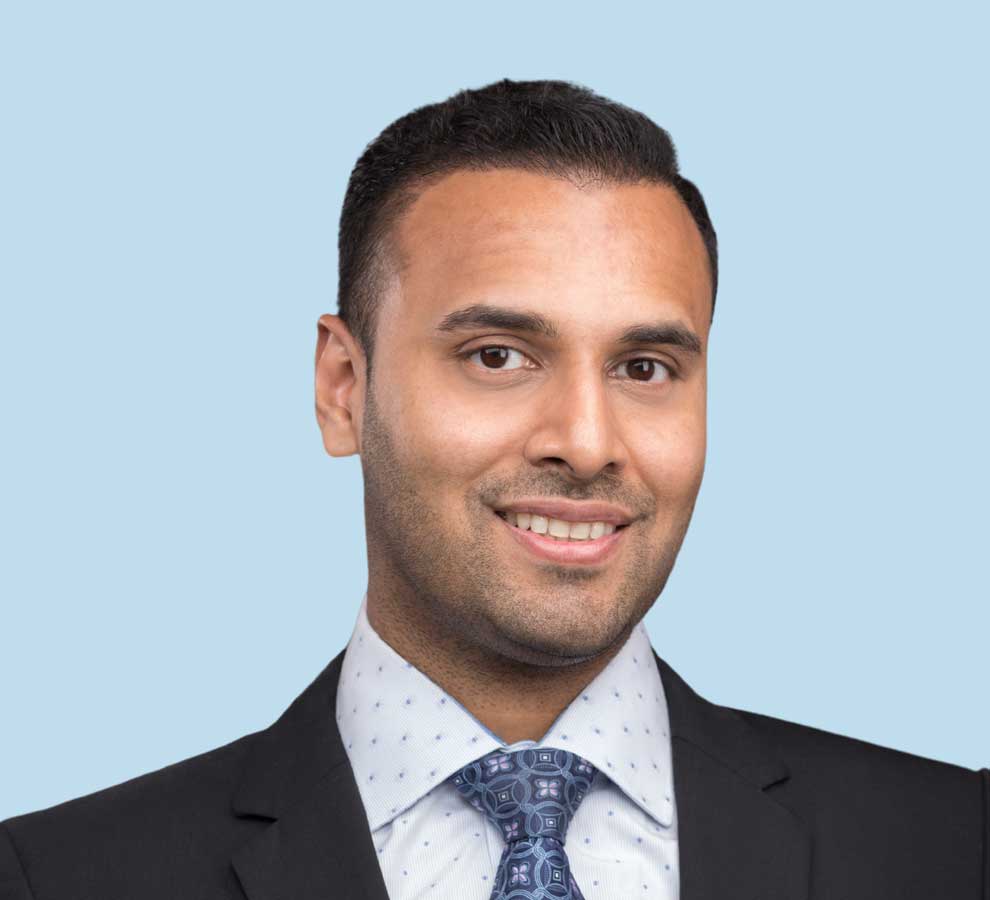 Adil A. Samad, MD professional headshot wearing black suit and floral print tie