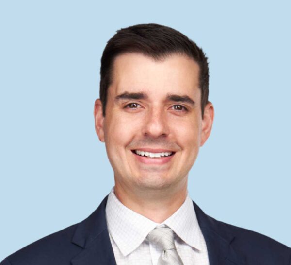 Alex Mierke, MD professional headshot wearing black suit and silver tie