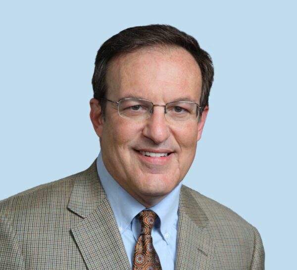 Alfred V. Hess, MD professional headshot wearing tan patterned suit with brown patterned tie