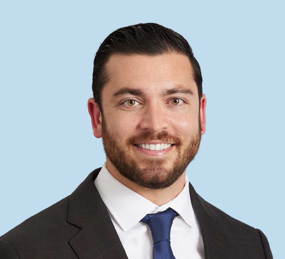 Andrew Boltuch, DO professional headshot wearing black suit and dark navy tie