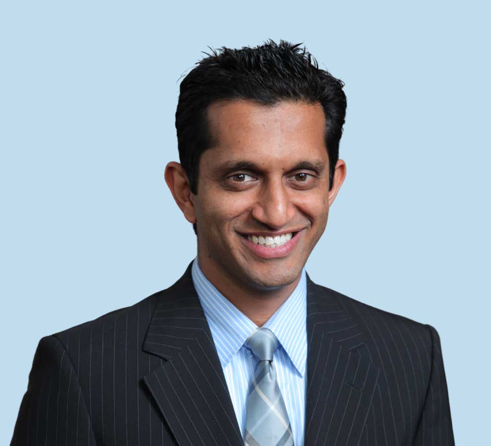 Anjan R. Shah, MD professional headshot wearing black pinstripe suit with light blue tie