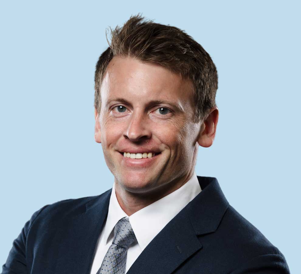 Christian D. Reintgen, MD professional headshot wearing black suit with textured gray tie