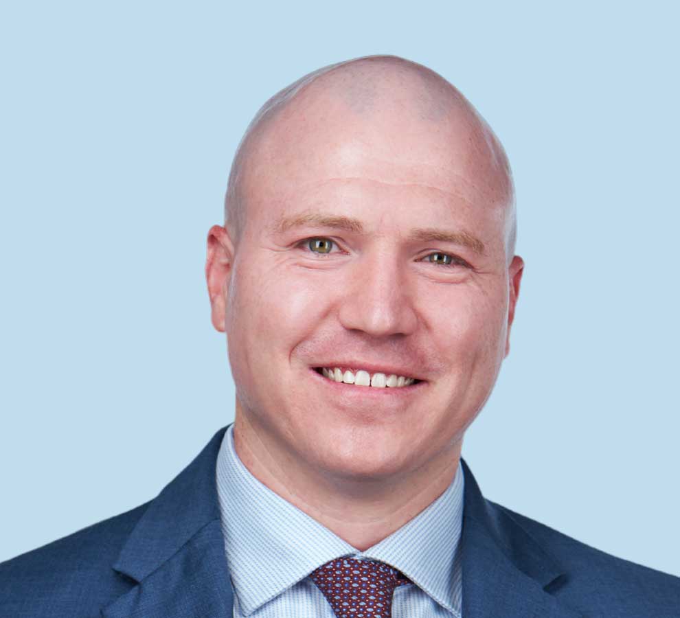 Christopher D. Flanagan, MD professional headshot wearing blue suit with red patterned tie