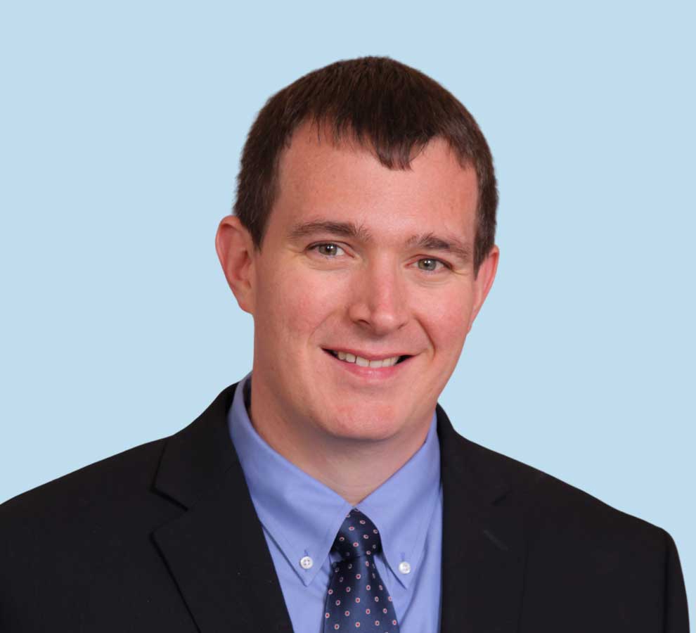 Christopher W. Grayson, MD professional headshot wearing black suit and blue tie