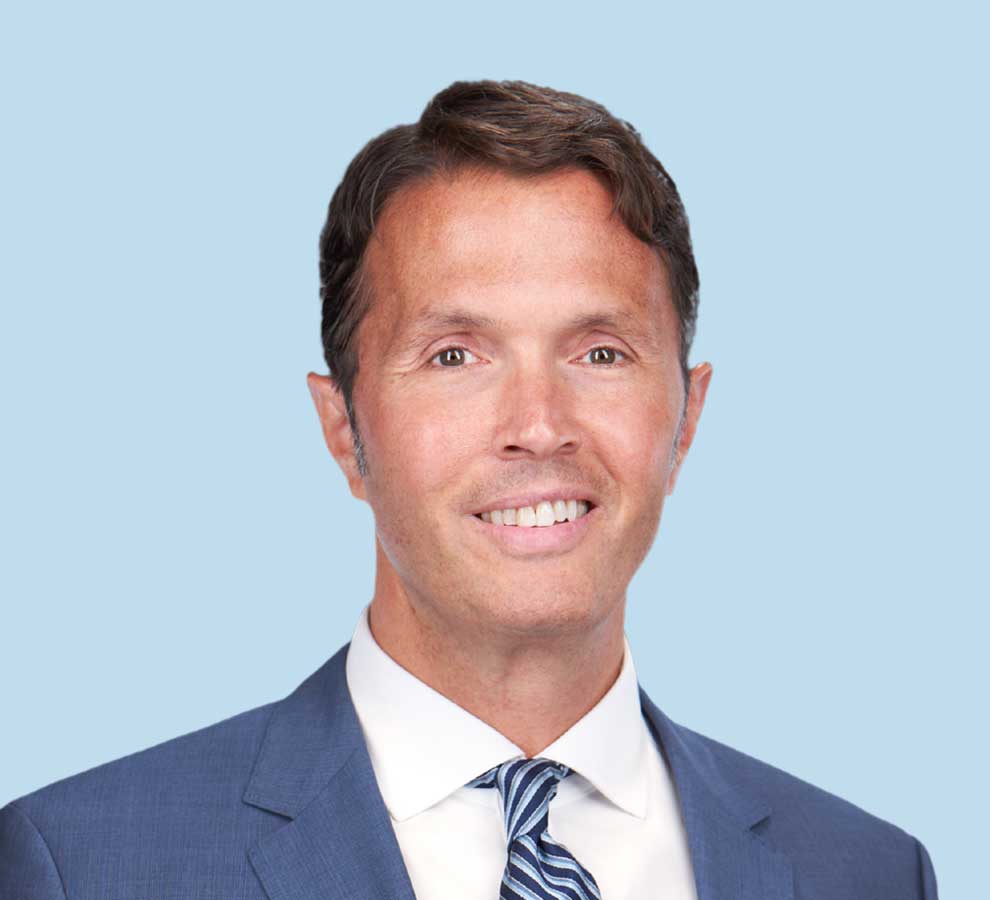 Craig S. Radnay, MD, MPH professional headshot wearing blue suit with blue striped tie