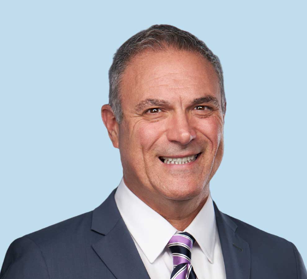 David A. Reina, DC professional headshot wearing slate gray suit and purple striped tie