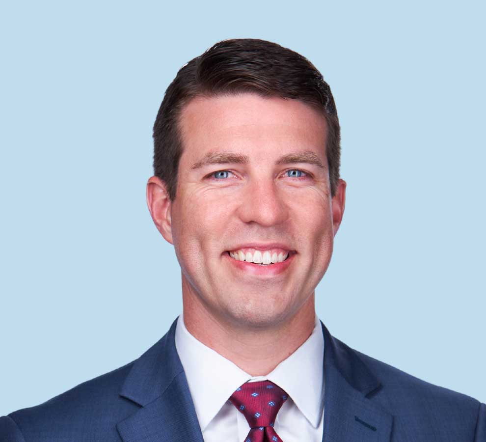 David B. Johnson, DO professional headshot wearing blue suit with bright red tie