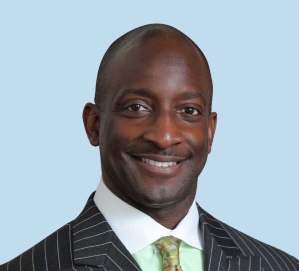 Eddie L. Echols, MD professional headshot wearing black pinstripe suit and green tie