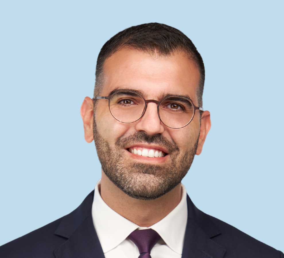 Georges Haidamous, MD professional headshot wearing black suit and dark purple tie