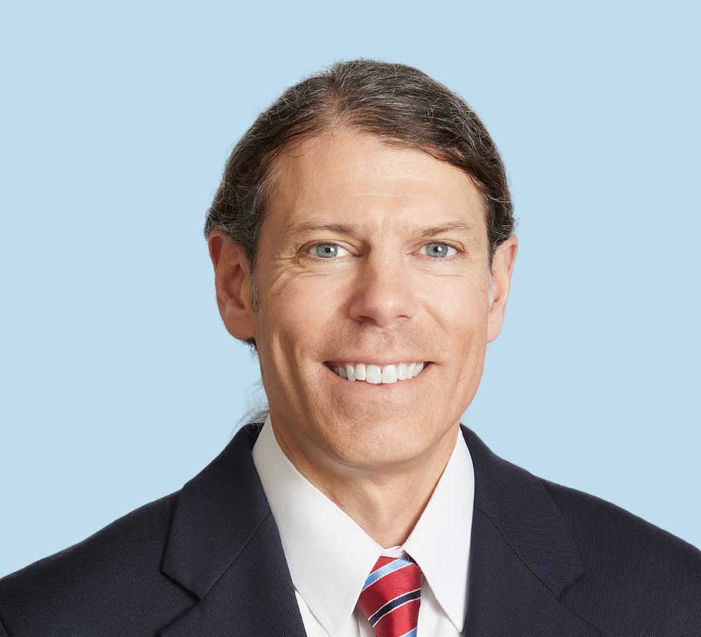 Glenn Fuoco professional headshot wearing black suit with red striped tie