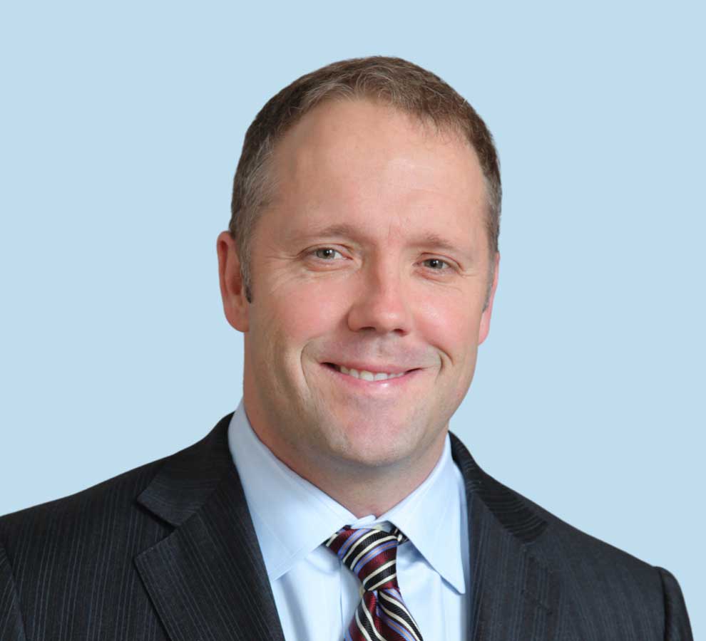 Grant G. Garlick, MD professional headshot wearing black suit and striped tie