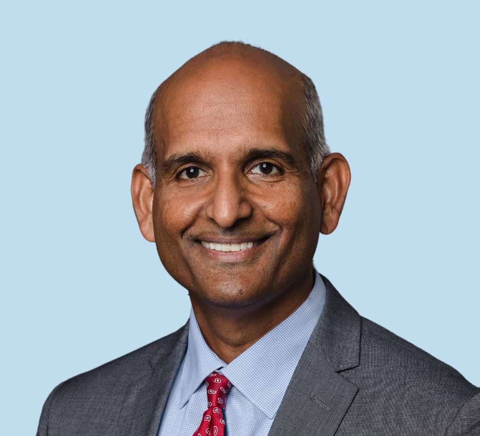 Hari Parvataneni, MD professional headshot wearing gray suit with red paisley tie