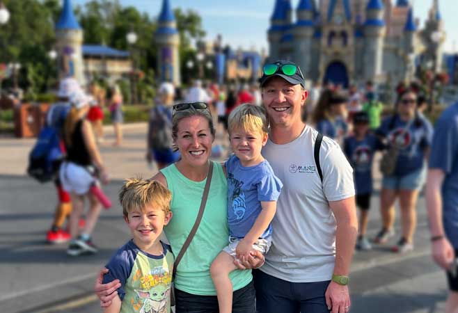 Dr. James Creighton with family at Disney World in front of castle