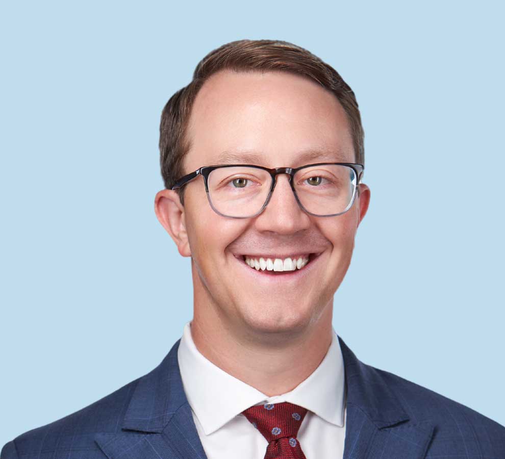 James J. Creighton III, MD professional headshot wearing blue suit and bright red tie