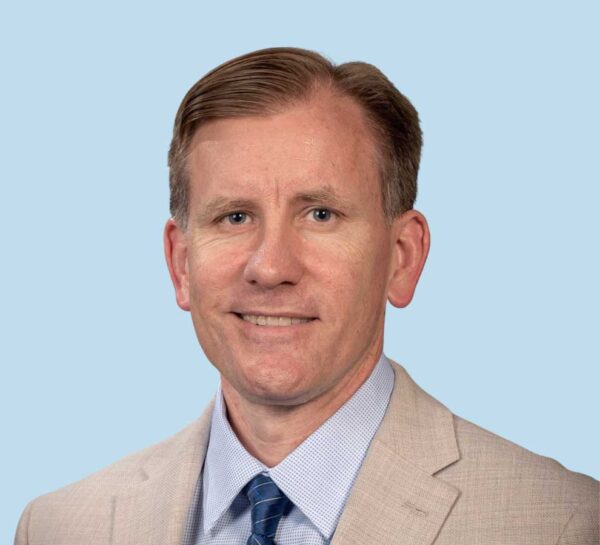 Dr. Jonathan Brown DPM professional headshot wearing brown suit and blue tie