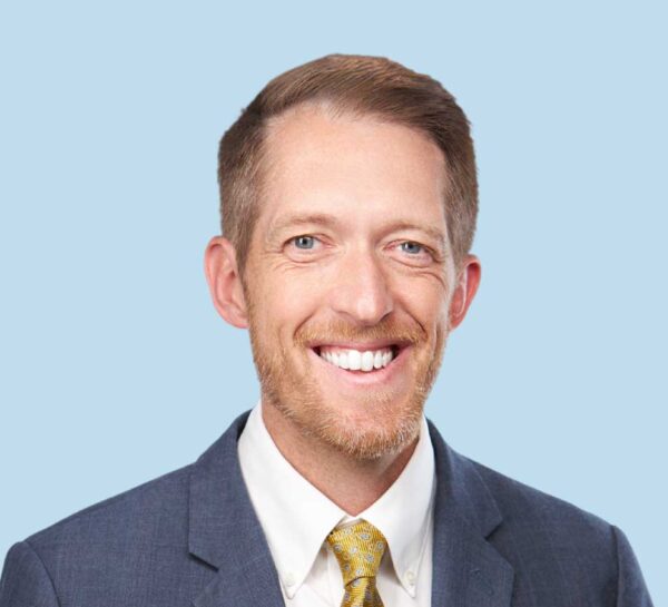 Joshua D. Linnell, MD professional headshot wearing slate blue suit and yellow tie