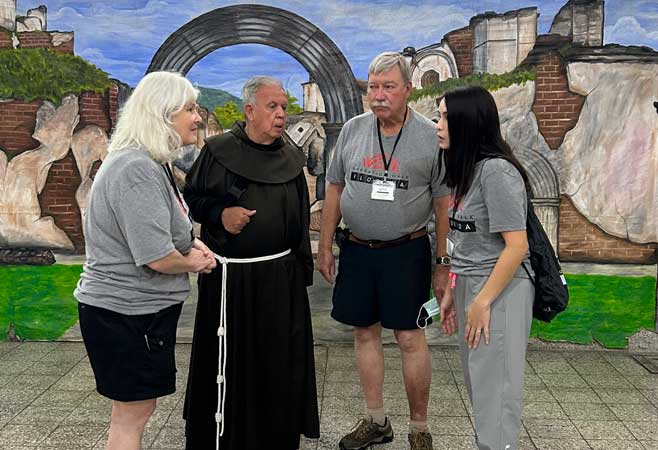 Dr. Kenneth Gustke standing against a painted mural