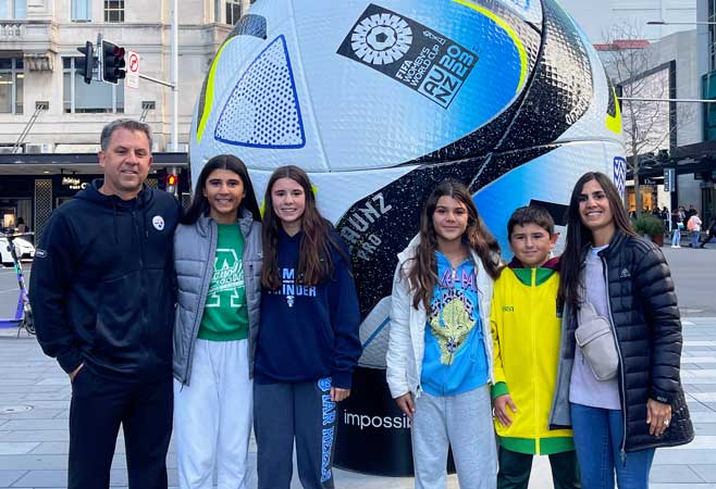 Dr. Miranda with family in front of giant soccer ball statue