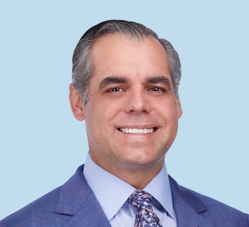 Michael J. Garcia, MD professional headshot wearing bright blue suit with floral navy tie