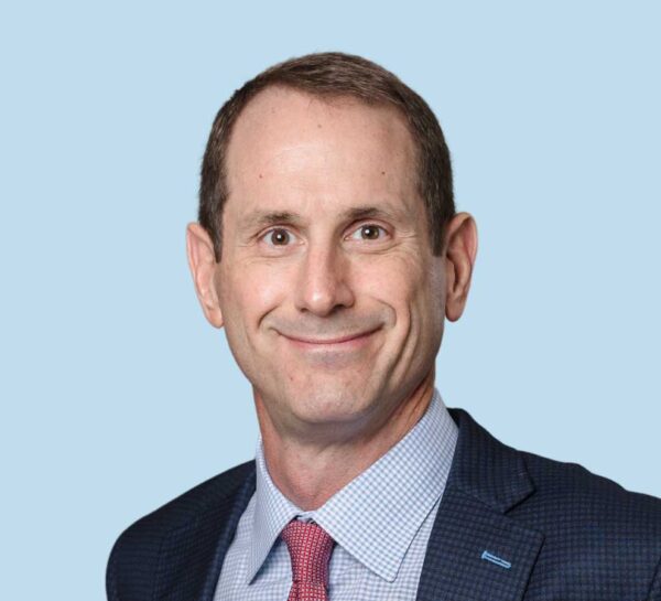 Michael Moser, MD professional headshot wearing black patterned suit with red checkered tie