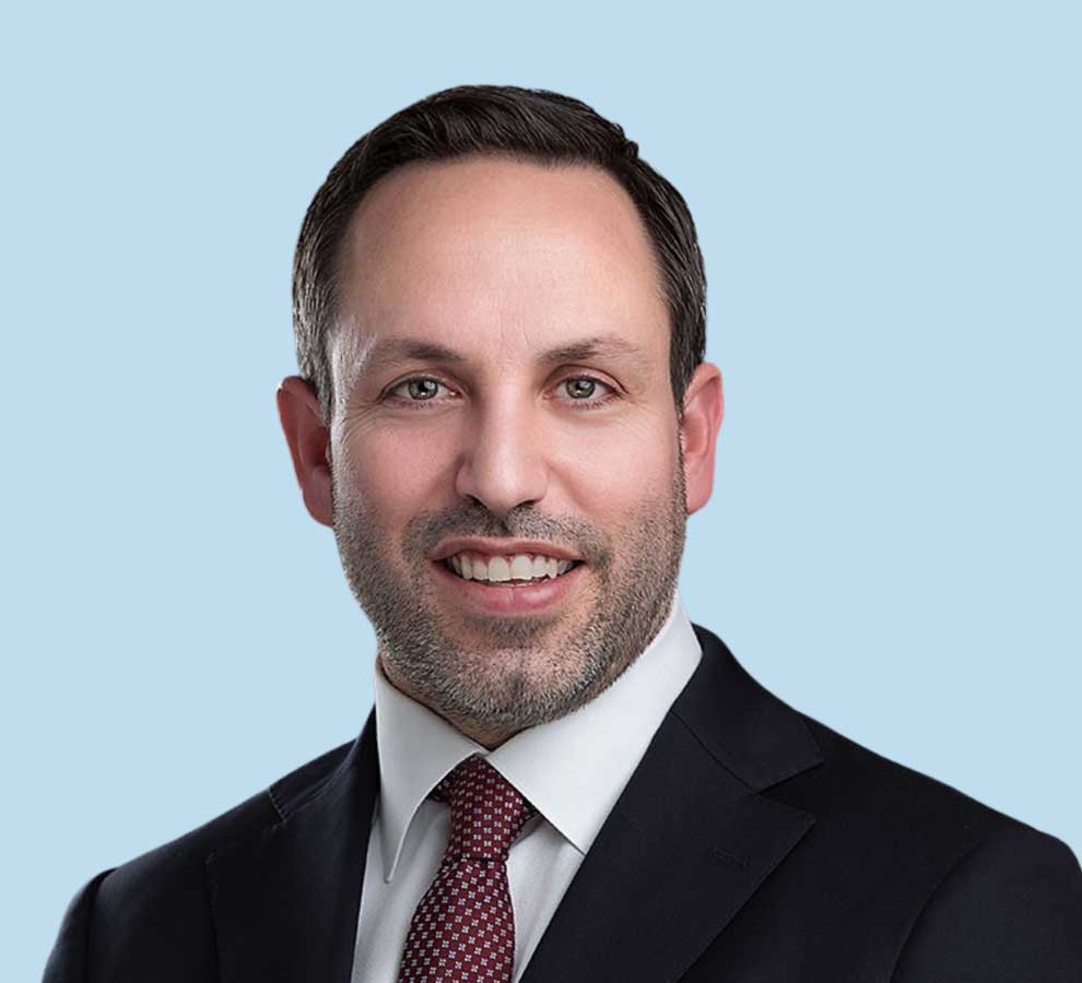 Dr. Samuel Swiggett professional headshot wearing black suit and red tie