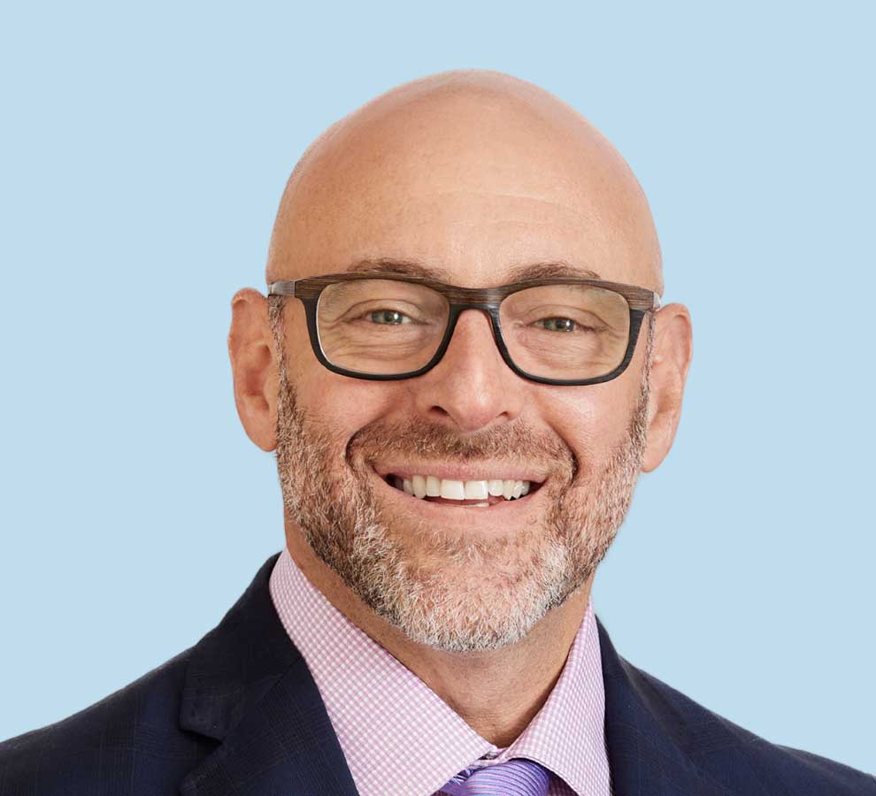 Scott Wisotsky, MD professional headshot wearing black suit with lavender tie