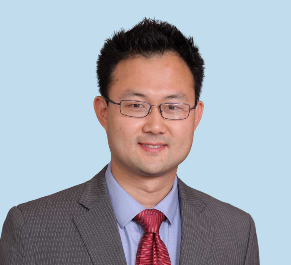 Seung Yin Yi, MD professional headshot wearing pinstripe suit with bright red tie