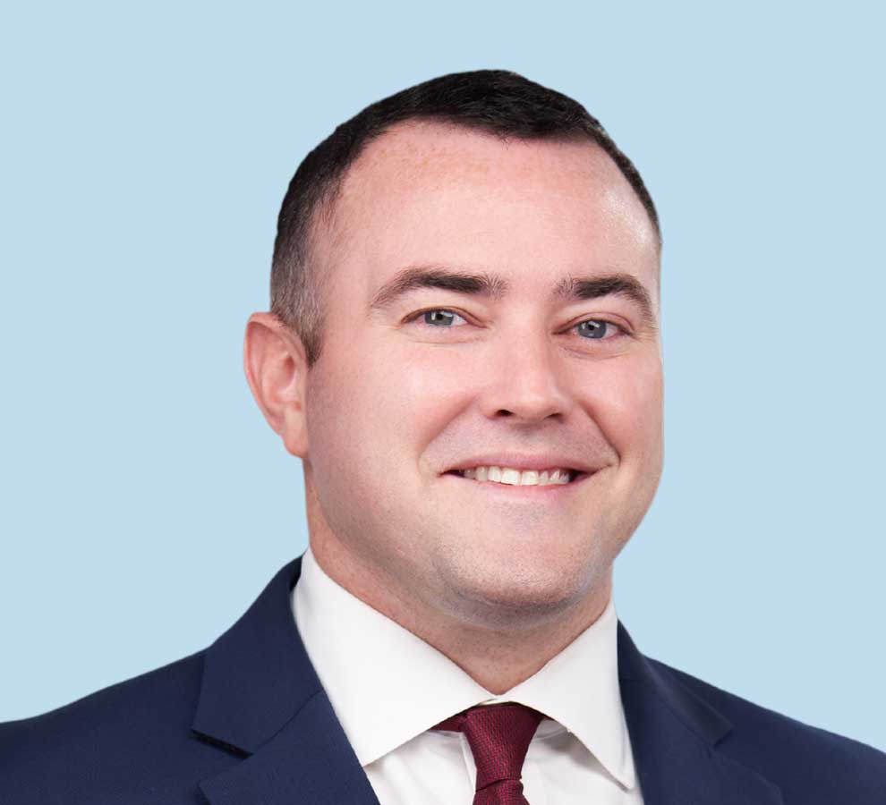 Spencer Smith, DO professional headshot wearing navy blue suit and dark red tie