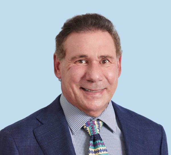 Steven Mirabello, MD professional headshot wearing blue suit with 90s style tie