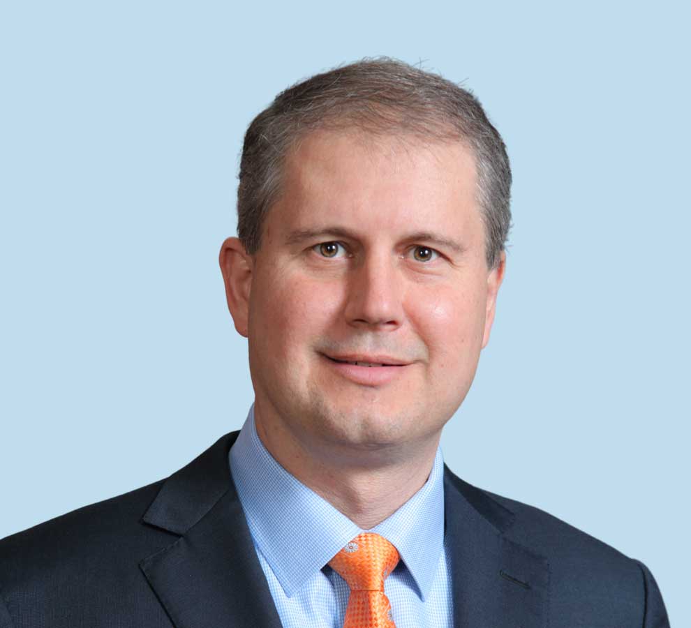 Steven T. Lyons, MD professional headshot wearing black suit and orange tie