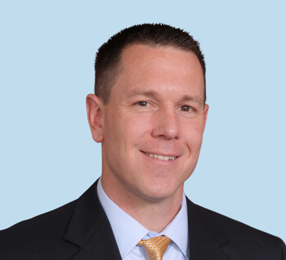 Timothy C. Epting, DO professional headshot wearing black suit and yellow patterned tie