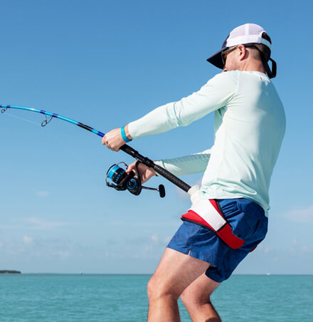 man struggling to reel in fishing rod