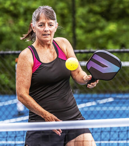 woman actively playing pickleball