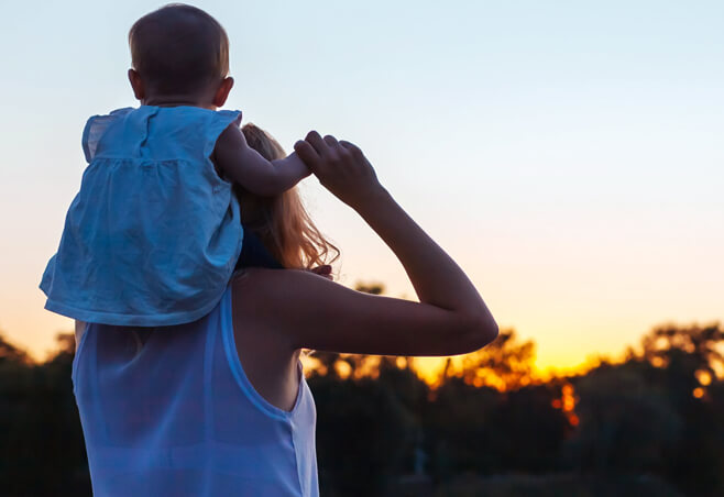 Mom carries daughter on her shoulders