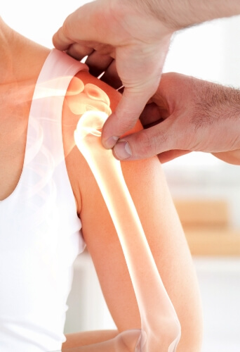 person holding woman's shoulder with indication of where bones are