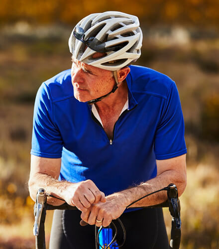 biker looking at nature on his bicycle after after receiving care from spine specialists